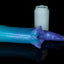 Fantasy shark-inspired silicone stroker in a gradient of teal to purple, featuring subtle ridges, twin pelvic fins framing the entrance, and a long, pointed tail, displayed on a black background. Next to the stroker is a grey soda can for scale.